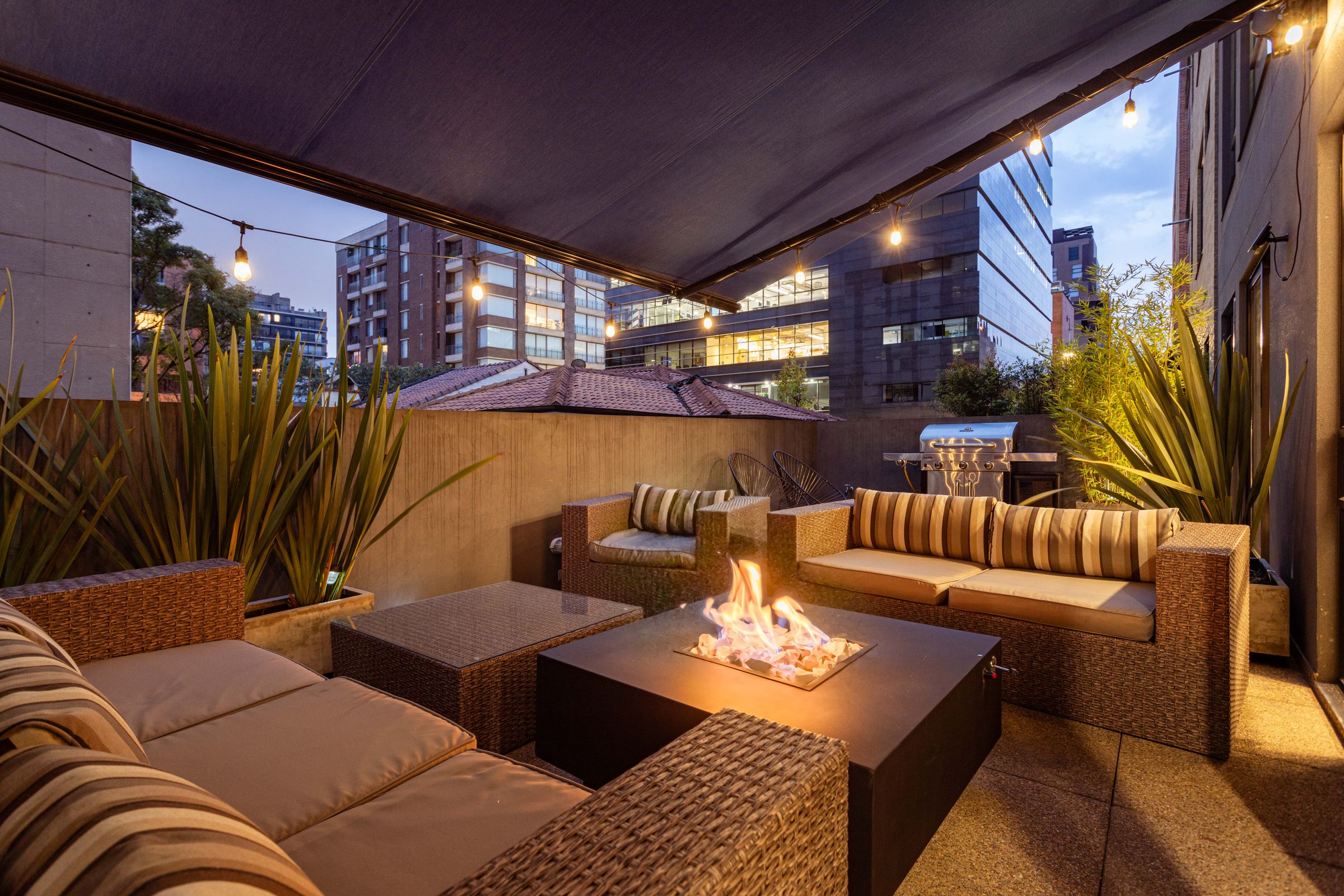 Terraço exterior ao anoitecer com zona de fogo