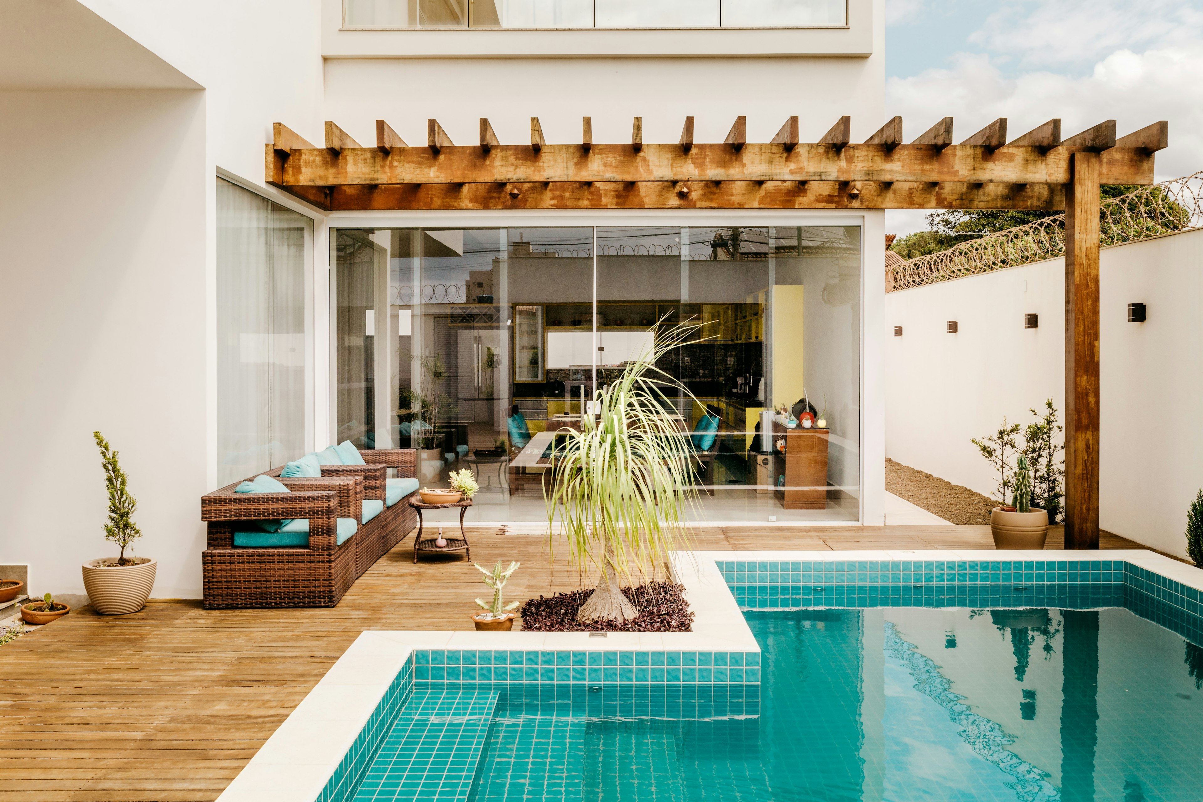 Deck de madeira junto a uma piscina, ao fim da tarde
